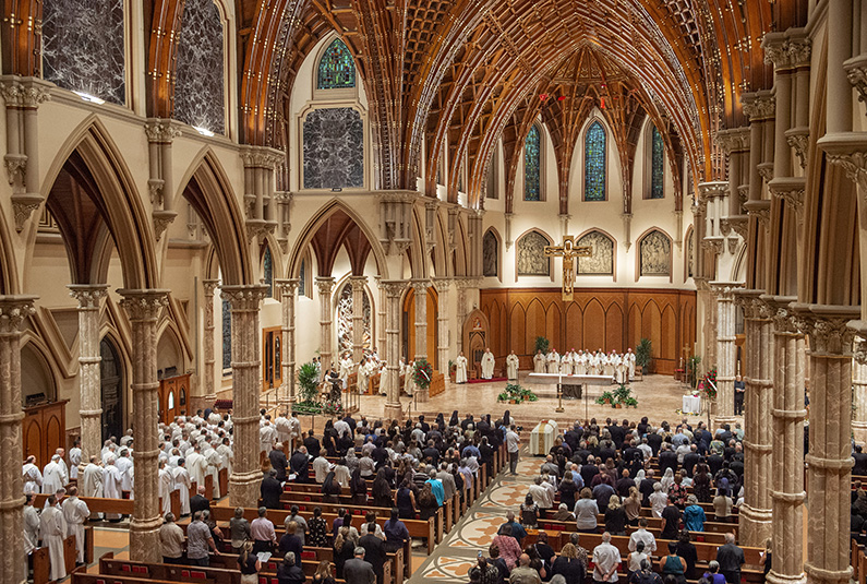 A funeral service being held at Holy Name Cathedral in Chicago.  Notice the beautiful funeral flowers.